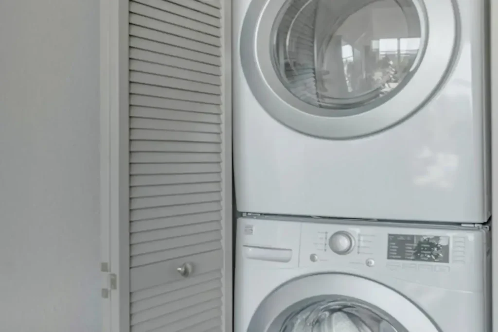 White stacked washer and dryer in a laundry room.