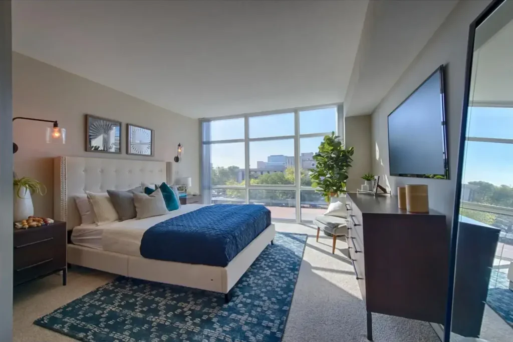 Bedroom with large floor-to-ceiling window at Cabochon at River Oaks high-rise apartments in Houston